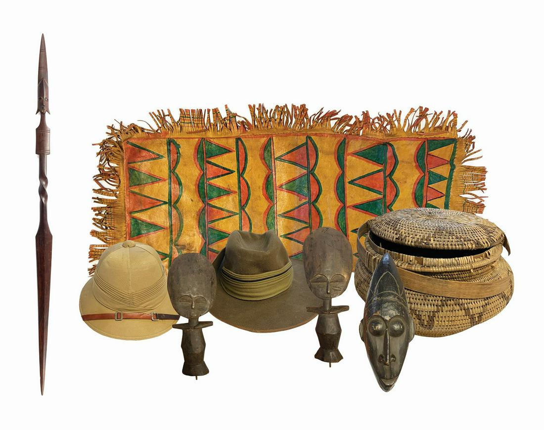 Collection of (8) Jungle Cruise Props.: (Walt Disney World, c.1980s-90s) A collection of (8) prop items from the Jungle Cruise attraction. The collection includes (3) hand-carved wooden figures, a basket with (5) pieces of costume jewelry i