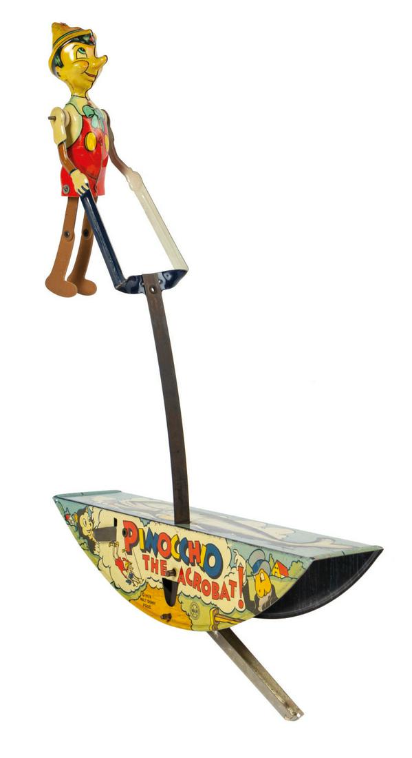 Pinocchio the Acrobat Wind-Up Tin Toy.: (Marx, 1939) A vintage Pinocchio the Acrobat wind-up toy manufactured by Marx. An articulated tin lithographic Pinocchio figure attaches to the base with a flat metal band. When the integral key in th