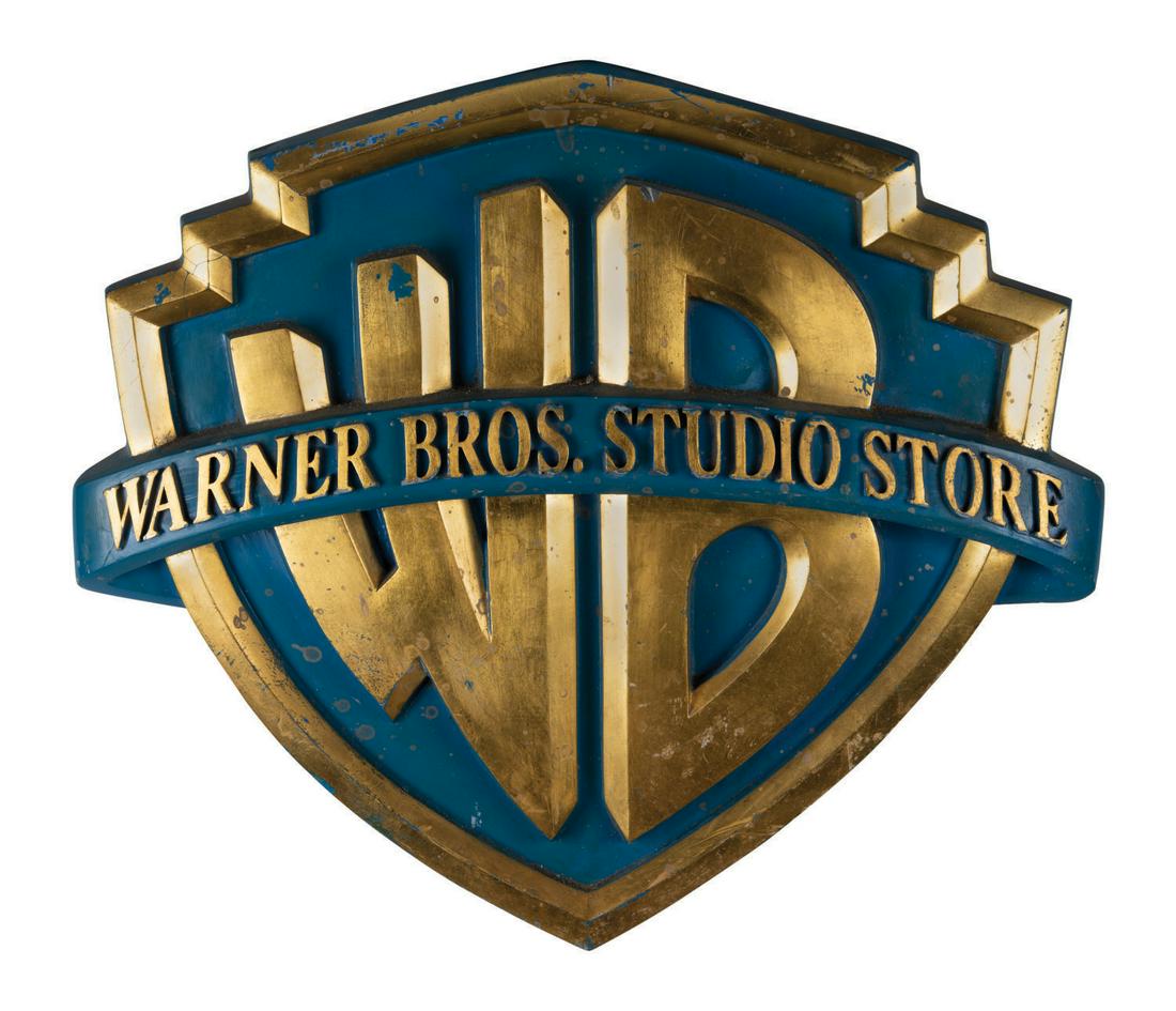 Warner Brothers Studio Store Sign.: (Warner Brothers, c.1991) A Warner Brothers Studio Store Sign featuring the corporate "WB" emblem. Signs like this one were a constant feature of the popular retail chain's decor and motif for a decad
