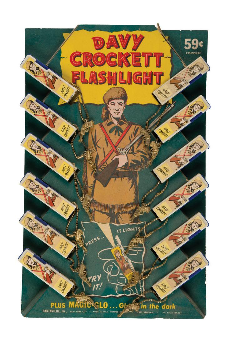 A Davy Crockett Flashlight Store Display.: (Bantam-Lite, 1950s) A rare store display for Davy Crockett Bantam-Lite flashlights. Including (12) flashlights, the 15"x9.5" display is in fine condition with slight wear from age, mainly to edges. T