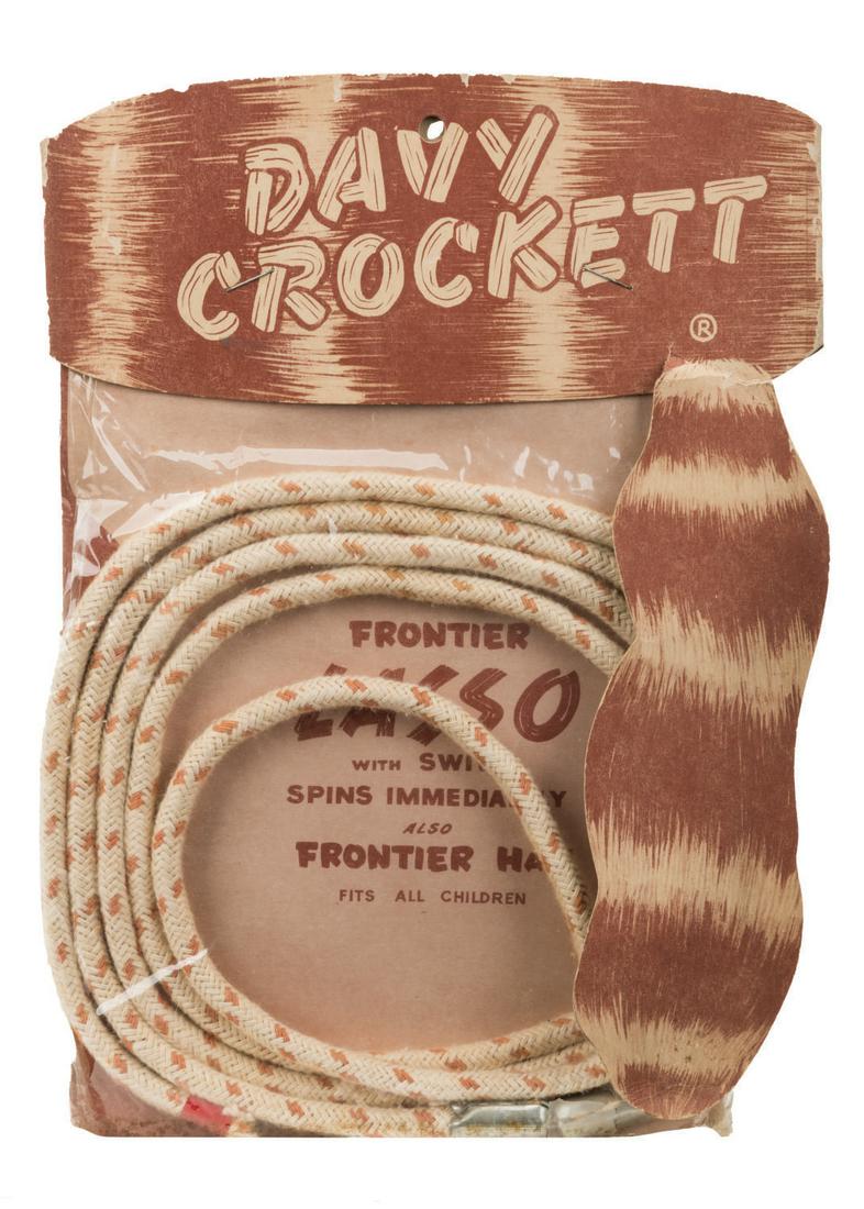 A Davy Crockett Frontier Lasso by White Eagle Trading.: (White Eagle, 1950s) A Davy Crockett Frontier Lasso by White Eagle Trading Corp. The braided lasso toy has a swivel for easy spinning and comes on a card with a paper Davy Crockett hat. The lasso is i