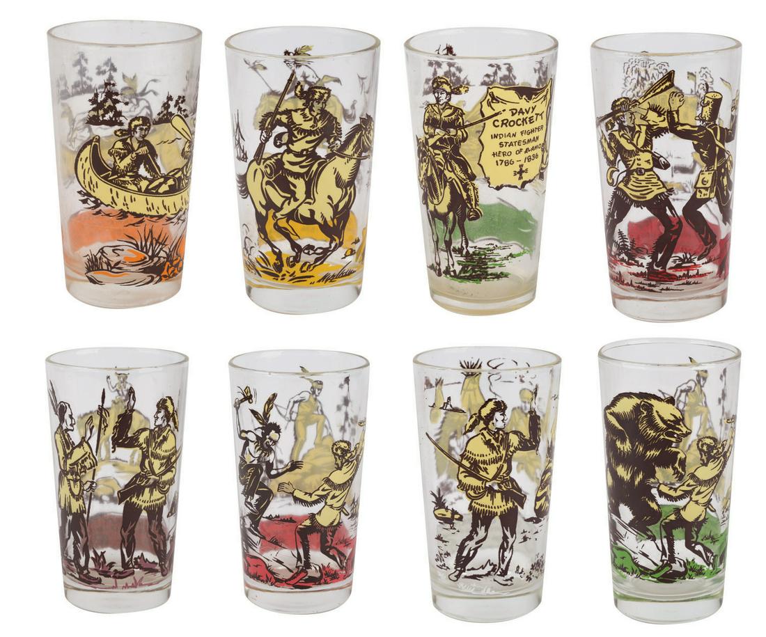 A Collection of (8) Davy Crockett Glasses.: (1950s) A Collection of (8) Davy Crockett glasses. Each glass has different images of Crockett in frontier adventures or defending the Alamo. Measuring 5"x2.75"each, the glasses are in fine condition 