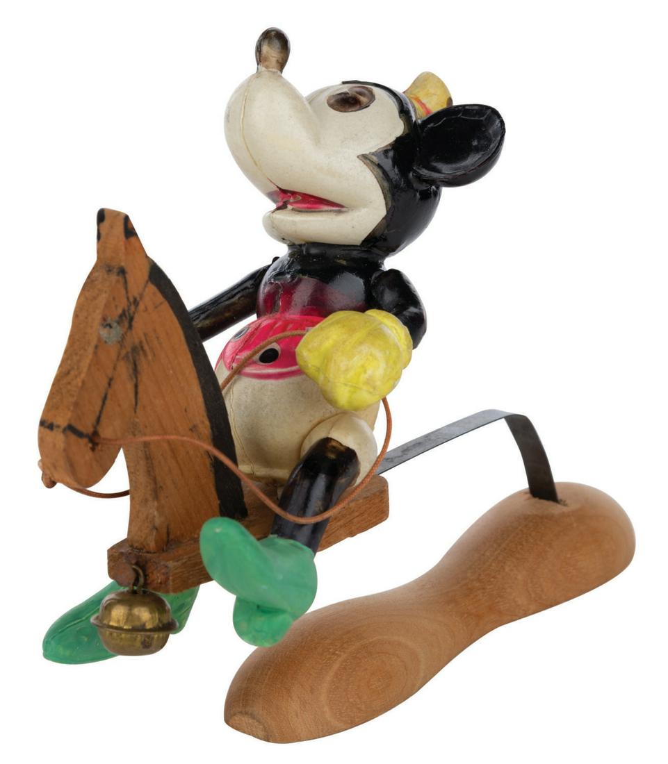 A Minnie Mouse Bouncing Toy.: (Japan, 1930s) An incredibly rare Minnie Mouse bouncing toy. The hand-painted Minnie celluloid figure sits atop a wooden rocking horse seat mounted to a piece of spring steel and was manufactured in J