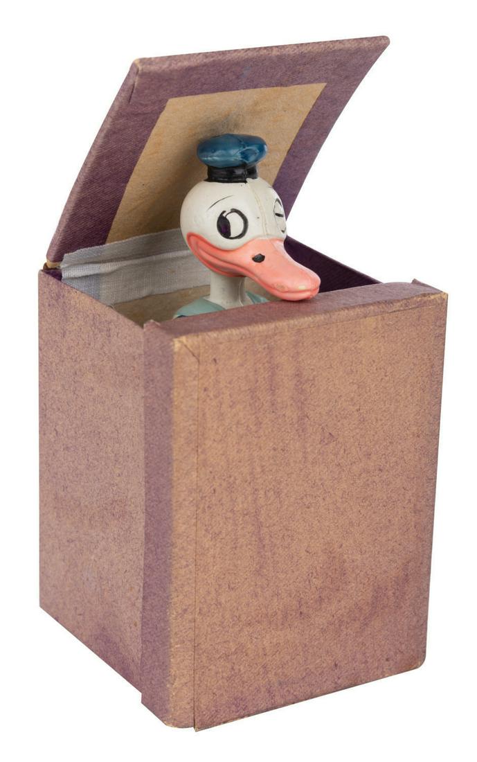 A Donald Duck Jack-In-The Box Toy.: (Japan, 1930s) A rare Donald Duck Jack-In-The-Box Toy. The toy was manufactured in Japan in the 1930s. The 3.25" tall cardboard box has a front panel that folds down and an inner lid that pops open to