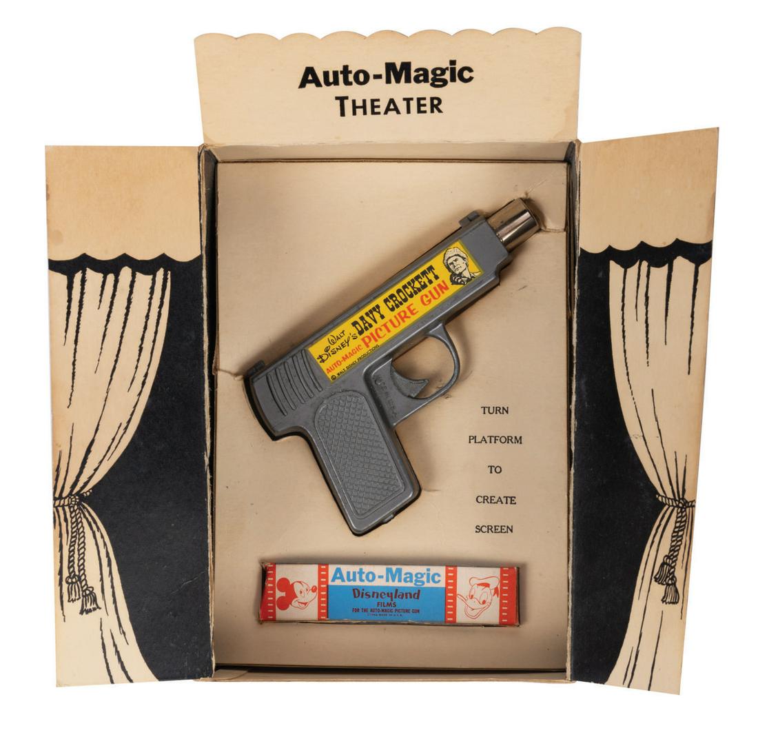 Walt Disney's Davy Crockett Auto-Magic Picture Gun.: (Stephens Products Co., 1955) A Davy Crockett Auto-Magic Picture Gun projector the original box. This metal gun-shaped toy opens vertically on hinges to reveal a battery compartment, a track for film