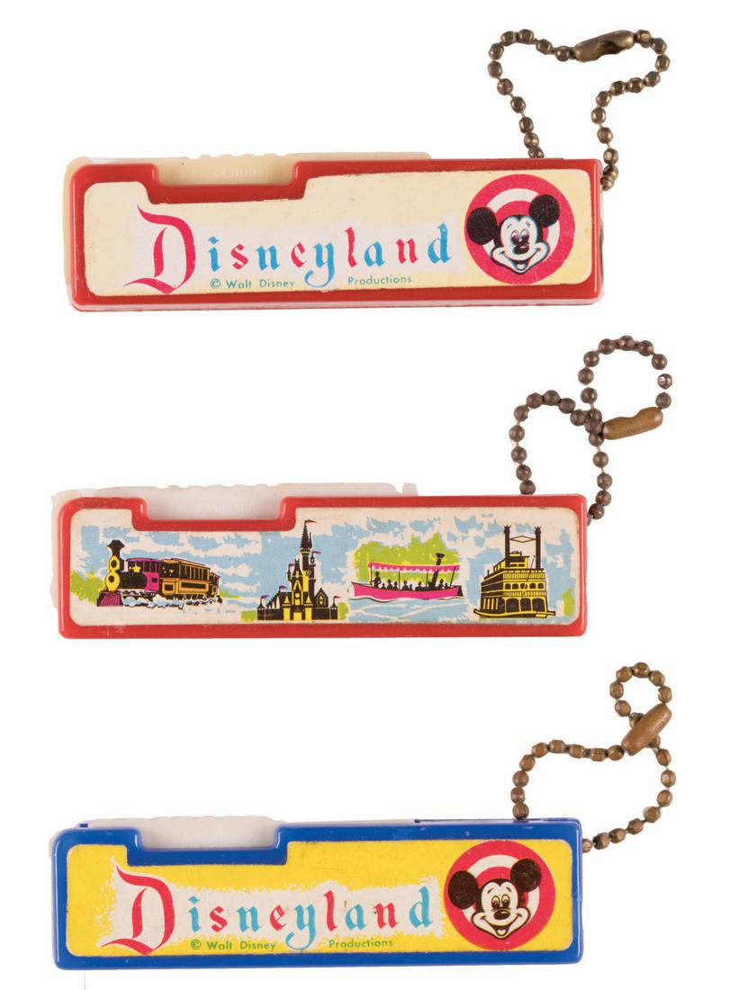 A Collection of Souvenir Keychain Flashlights.: (Disneyland, 1950s-60s) A collection of (3) souvenir Disneyland flashlights. The plastic flashlights have ball chains and are decorated with labels featuring Mickey Mouse and iconic park attractions.