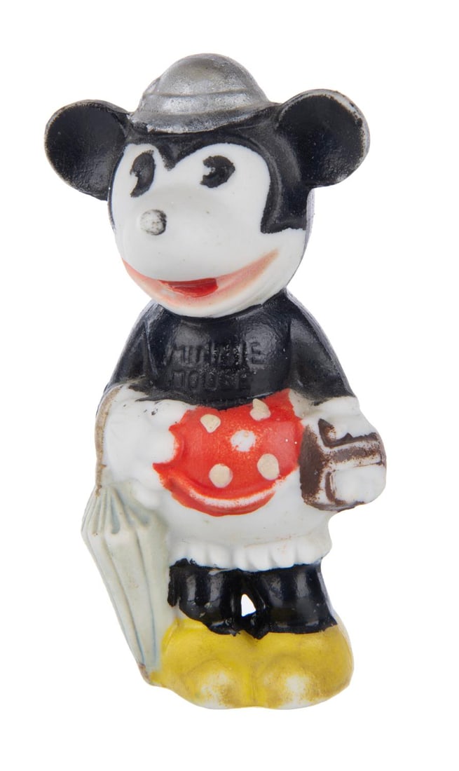 A Minnie Mouse Bisque Figure.: (Japan, 1930s) A rare bisque figure of Minnie Mouse with her umbrella and purse, manufactured in Japan. Measuring 3.5" tall, this figure is in very good condition with scuffs and wear.