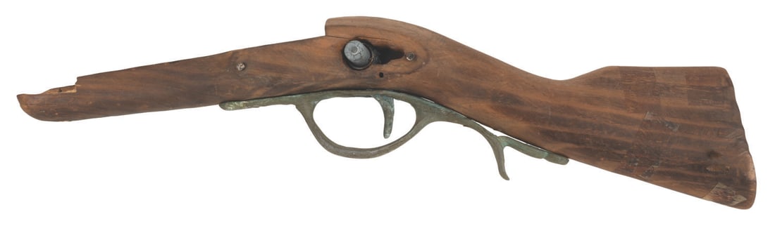 A Pieces of Eight Shop Rifle Gun Prop.: (Disneyland, 1970s) A prop rifle from the Pieces of Eight shop in New Orleans Square. Measuring 16.75" x 6" x 2", the intentionally distressed wood and metal prop is in good condition with scuffs, chi