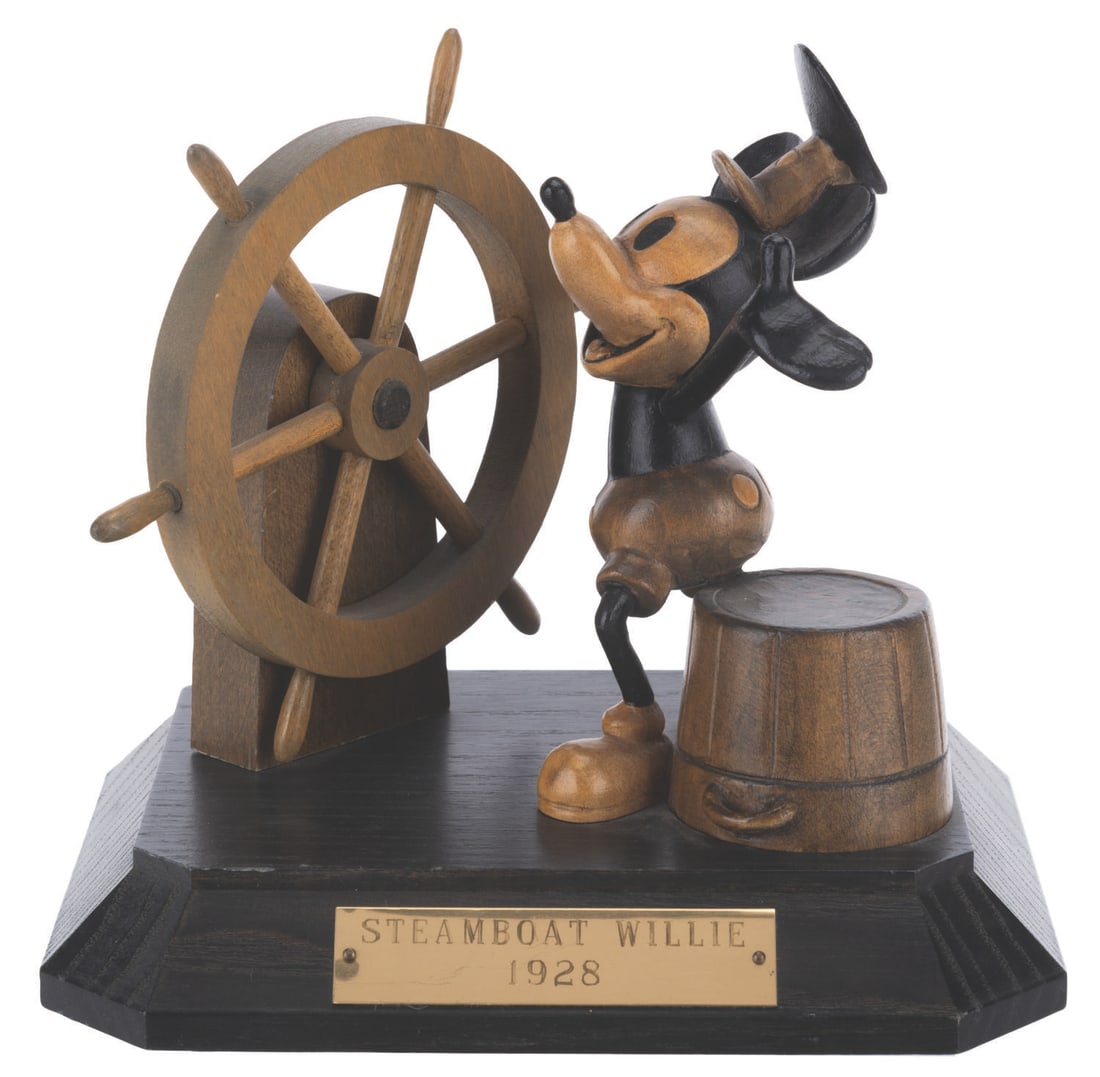 A Wooden Mickey Mouse “Steamboat Willie" Sculpture by ANRI.: (ANRI, 1989) A carved wood figurine of Mickey Mouse as Steamboat Willie by ANRI. Willie displays on a wooden base with a brass title plaque and is numbered 503 in a limited edition of 1000. Measuring