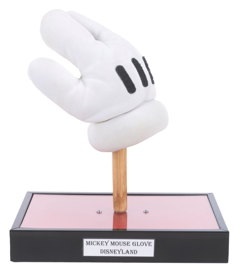 A Mickey & Minnie Mouse Character Glove.: (Disneyland, 2003) A glove worn by Mickey or Minnie Mouse for character meet and greets at Disneyland. The glove contains the original costume tag and comes with a custom-made display stand. Measuring