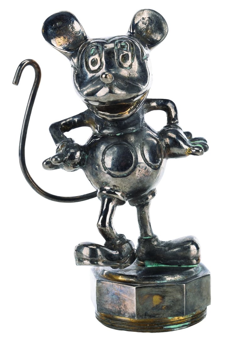 A Mickey Mouse Radiator Cap Hood Ornament.: (Disney, 1920s-30s) An early Mickey Mouse figural radiator cap. The heavy, plated brass hood ornament has a 1?" threaded base for radiator mounting. Measuring 5.25" tall, Mickey is in good condition w