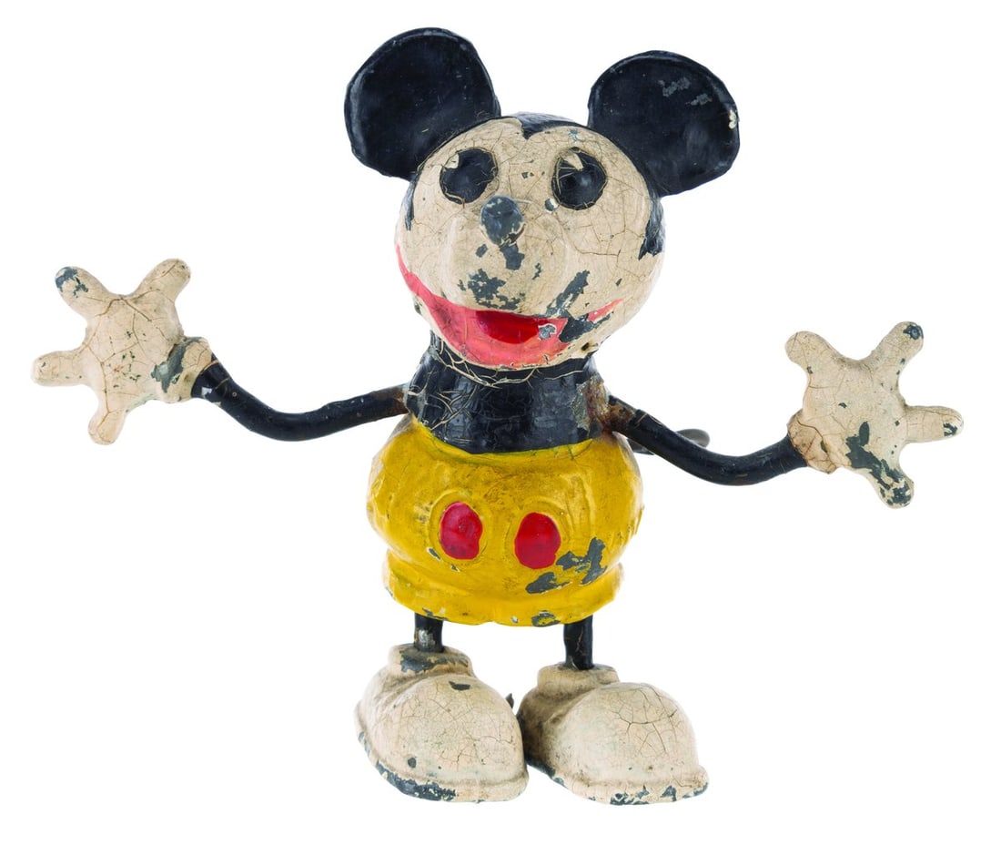 A Mickey Mouse German Metal Figure.: (Germany, 1932) A metal Mickey Mouse figure manufactured in Germany. Measuring 2" x 4" x 3" tall, the figure is in fair condition with heavy crazing throughout, paint loss, oxidation, and wear.
