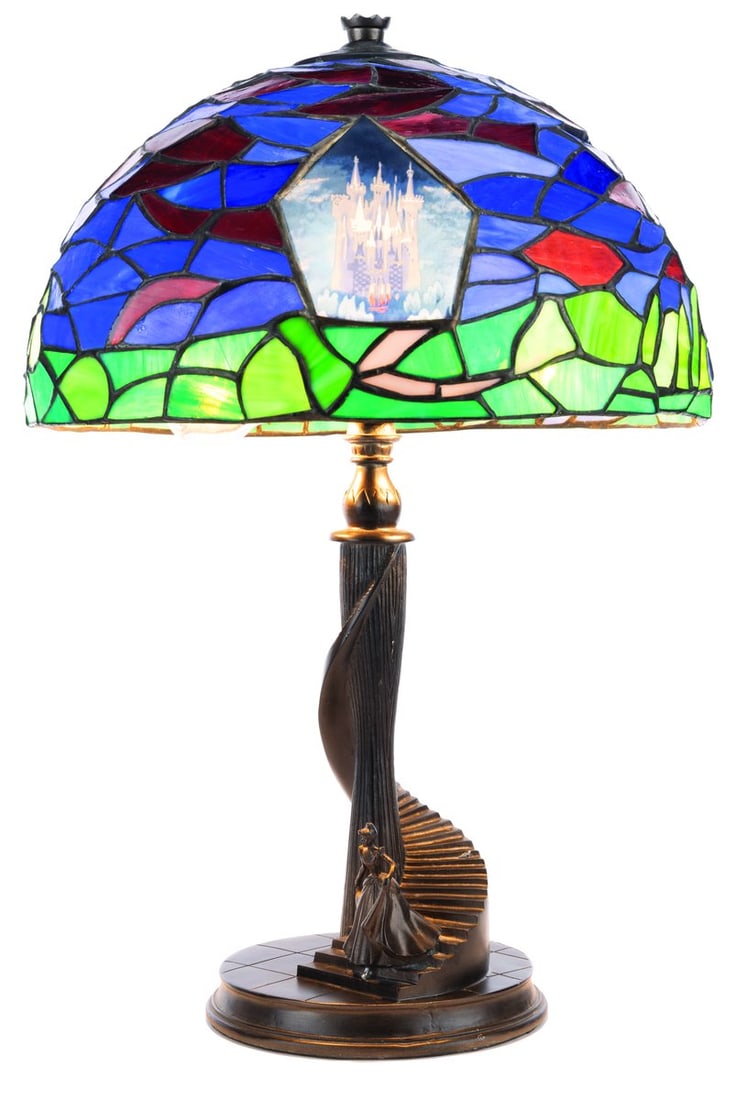 A "Cinderella" Stained-Glass Lamp by Jody Daily.: (Disney, 2003) A stained-glass “Cinderella” lamp by Jody Daily, released in a limited edition of 1500. When the stained-glass shade is illuminated, a silhouette of Cinderella's carriage appear