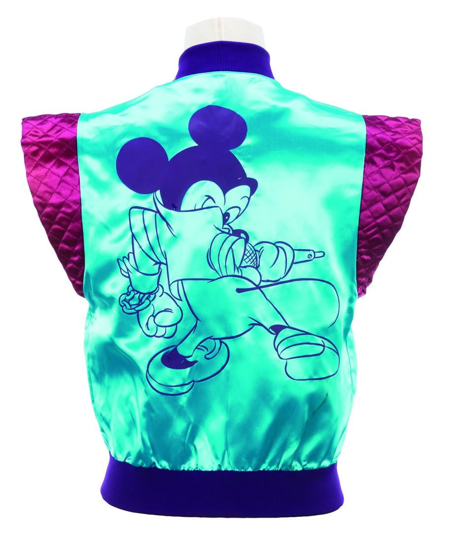 A Rare Disney Character Fashions Mickey Mouse Vest.: (Disney, 1980s) A rare Disney Character Fashions acetate vest featuring Mickey Mouse on the back, in a style reminiscent of Captain EO. Labeled a size medium, the vest is in fair condition with stains