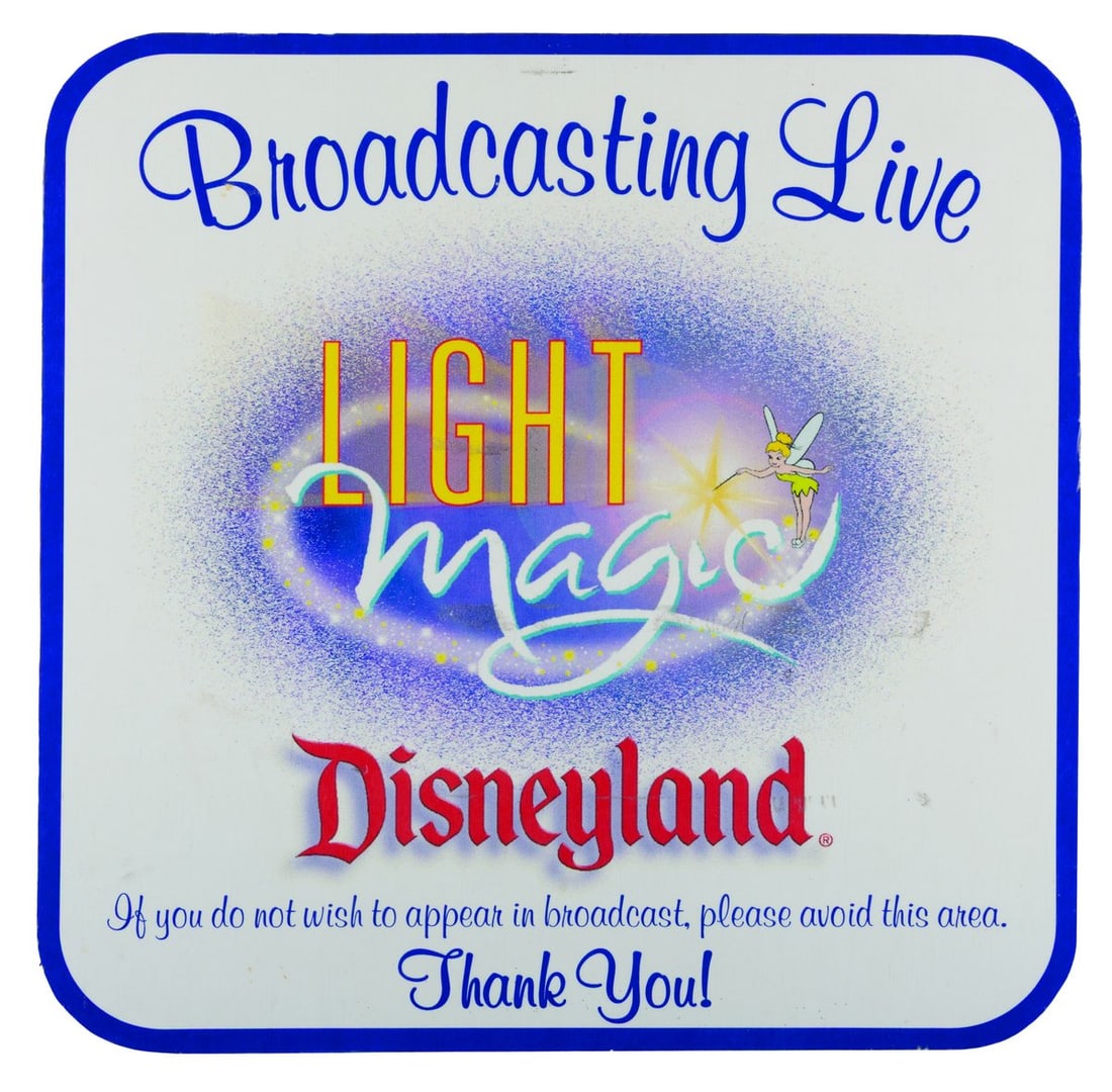 A Disneyland Light Magic Broadcasting Live Sign.: (Disneyland, 1997) A Light Magic parade sign featuring Tinker Bell, alerting Guests of filming taking place. Measuring 19" x 19", the sign is in good condition with typical scratches, edge wear, and s