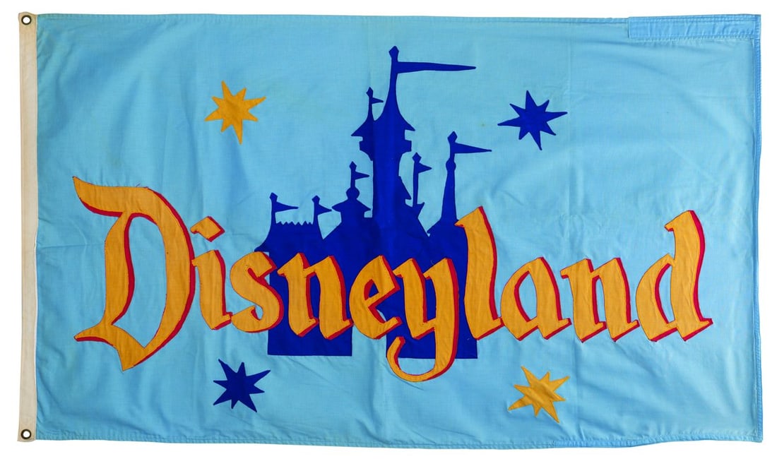 An Official Flag of Disneyland.: (Disneyland, 1955-80s) An official flag of Disneyland featuring Sleeping Beauty Castle. The double-sided flag is the style that once flew over Main Street Station and features bright, three-color embr