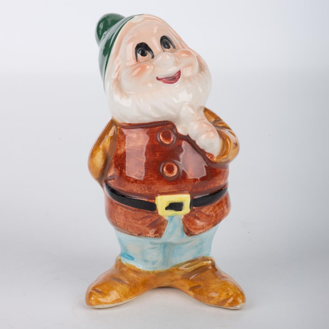 A “Snow White?? Happy Ceramic Figurine.: (Disney, 1970s-90s) A ceramic figurine of Happy from “Snow White and the Seven Dwarfs.” Measuring 2.25” x 2.5” and 3.5” tall, the figurine is in good condition with small