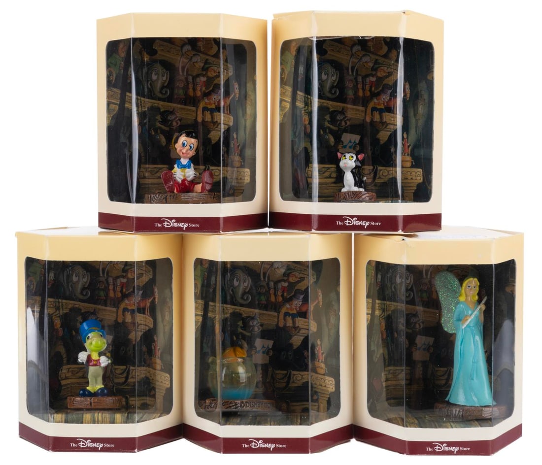 A “Pinocchio?? Tiny Kingdom Figurine Collection.: (Disney Store, 1990s) A collection of five “Pinocchio” Tiny Kingdom figurines in their original boxes, including Cleo, Figaro, the Blue Fairy, Jiminy Cricket, and Pinocchio. Measuring