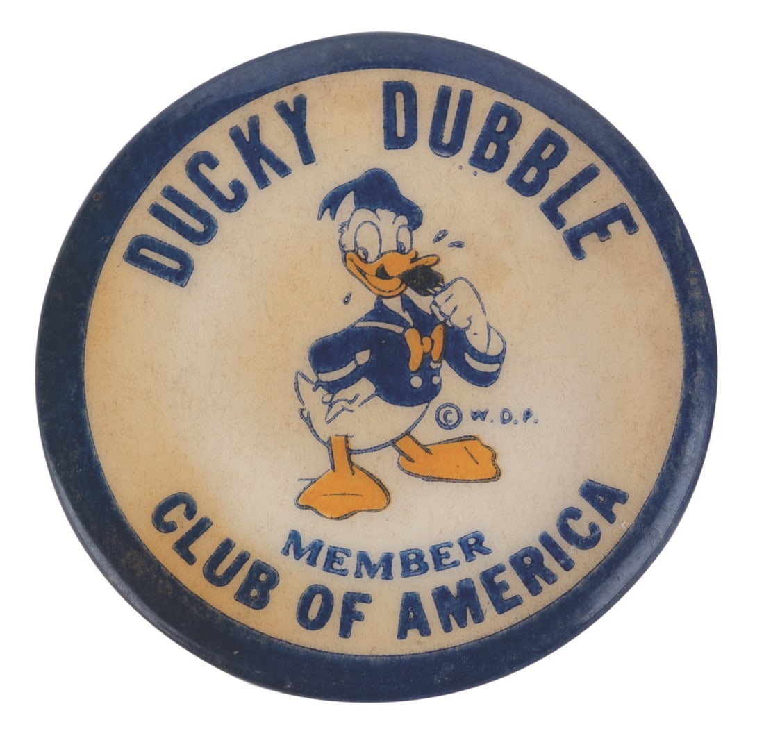 A Ducky Dubble Club of America Membership Button.: (Hi-Grade, 1950s) A rare button advertising Donald Duck Ducky Dubble Ice Cream. Measuring 1.25” in diameter, the button is in good condition with oxidation to the reverse, slight discoloration,