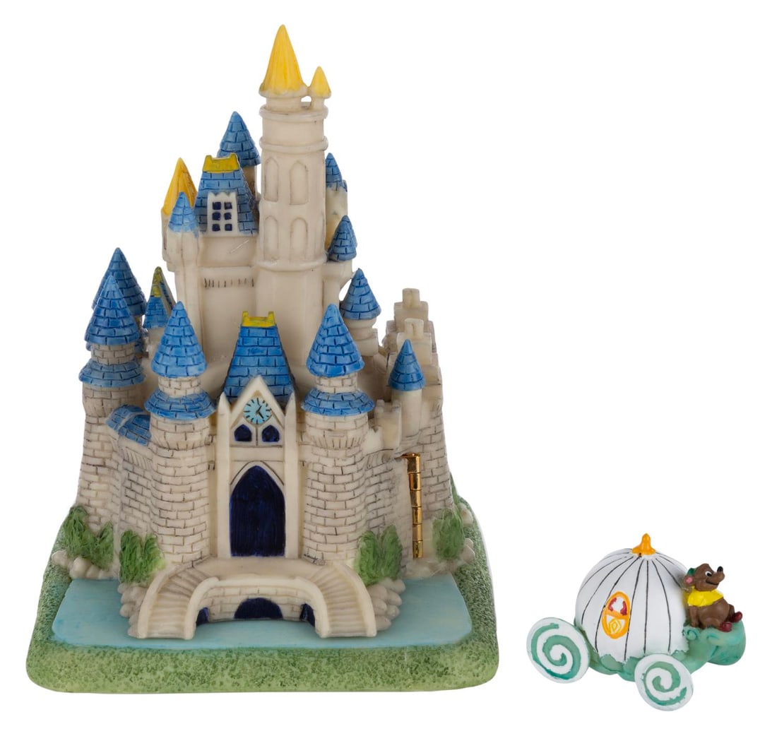 A Cinderella Castle Trinket Box.: (Disney, 1990s) A Cinderella Castle trinket box. When opened, the box reveals a relief of Cinderella and a miniature carriage figurine featuring Gus. Measuring 4" x 4.25" x 5.5", the box is in fine
