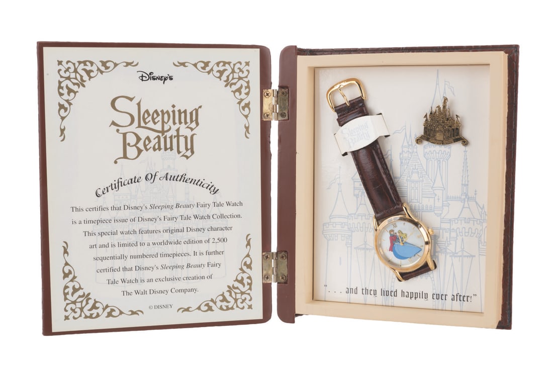 A "Sleeping Beauty" Fairy Tale Watch Set.: (Fossil, 1990s) A Fairy Tale Watch Collection "Sleeping Beauty" watch with a pin in a storybook-shaped presentation box. The set was released in a limited edition of 2,500. The 6.5" x 5.5" x 1.5"