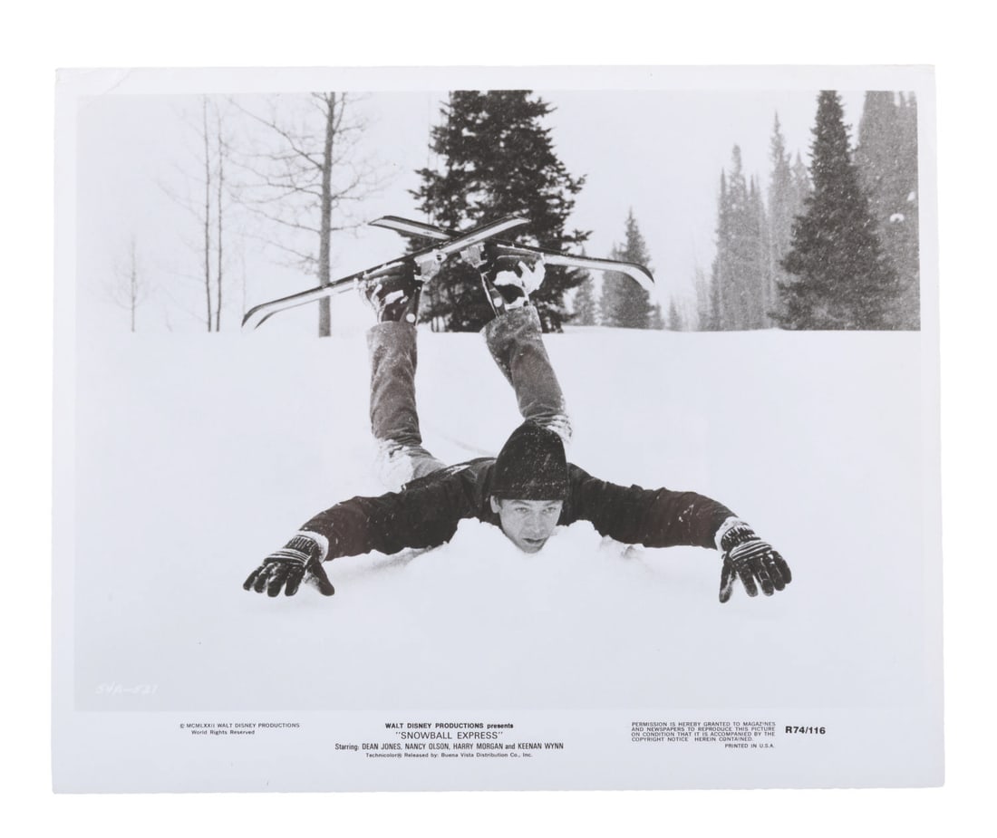 A "Snowball Express" Publicity Photo.: (Disney, 1972) A publicity photo for "Snowball Express" starring Dean Jones, Nancy Olson, and Harry Morgan. Measuring 8" x 10", the photo is in good condition with scratches, creases, and a fold at th