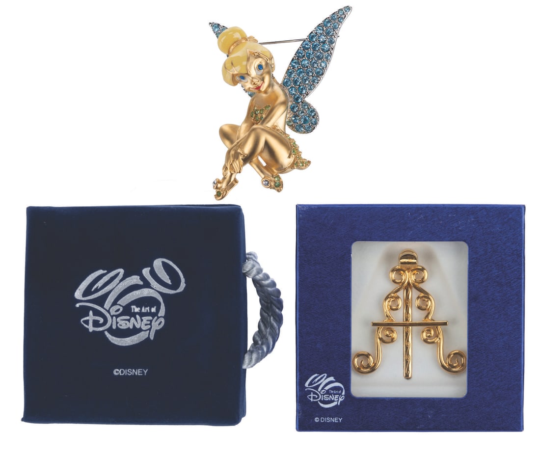 A Swarovski Tinker Bell Pin with Stand.: (Disney, 2000s) A limited edition 2000 Tinker Bell brooch with Swarovski crystal wings and accents, and a matching display stand. Measuring 1.75" x 2.25", the brooch is in fine condition.