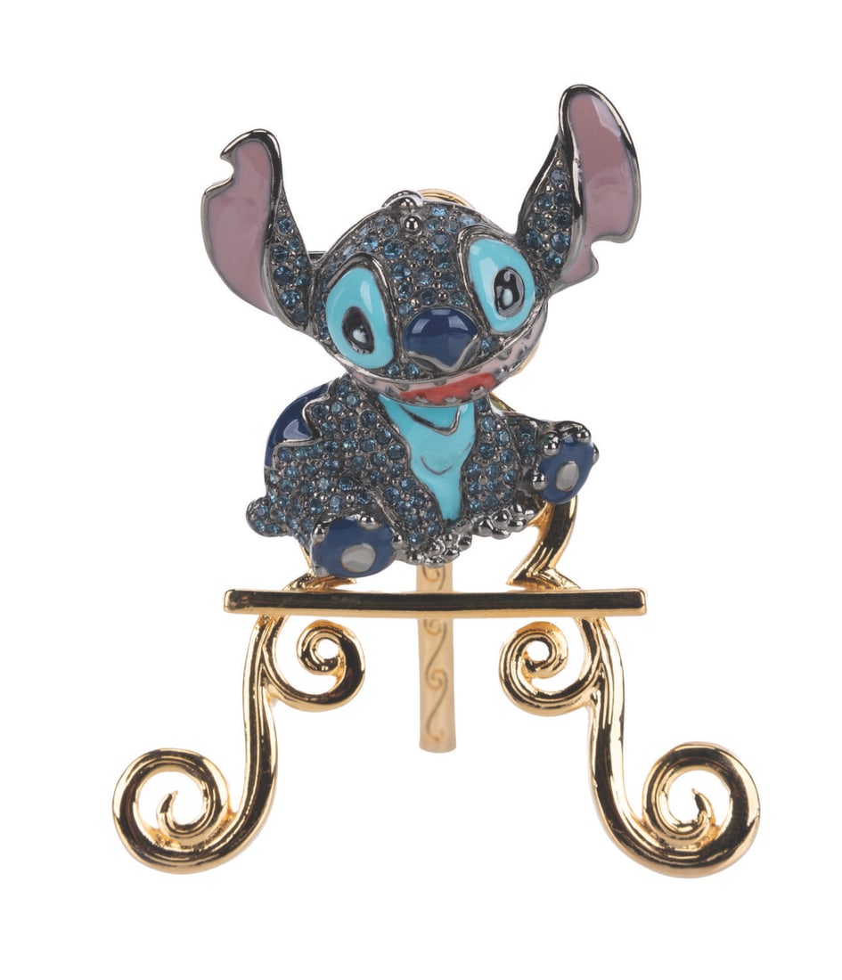 A Swarovski Stitch Pin with Stand.: (Disney, 2000s) A limited edition 1500 Swarovski crystal Stitch brooch with a matching display stand. Numbered 0184/1500, the brooch, measuring 1.5" x 1.5", is in fine condition.