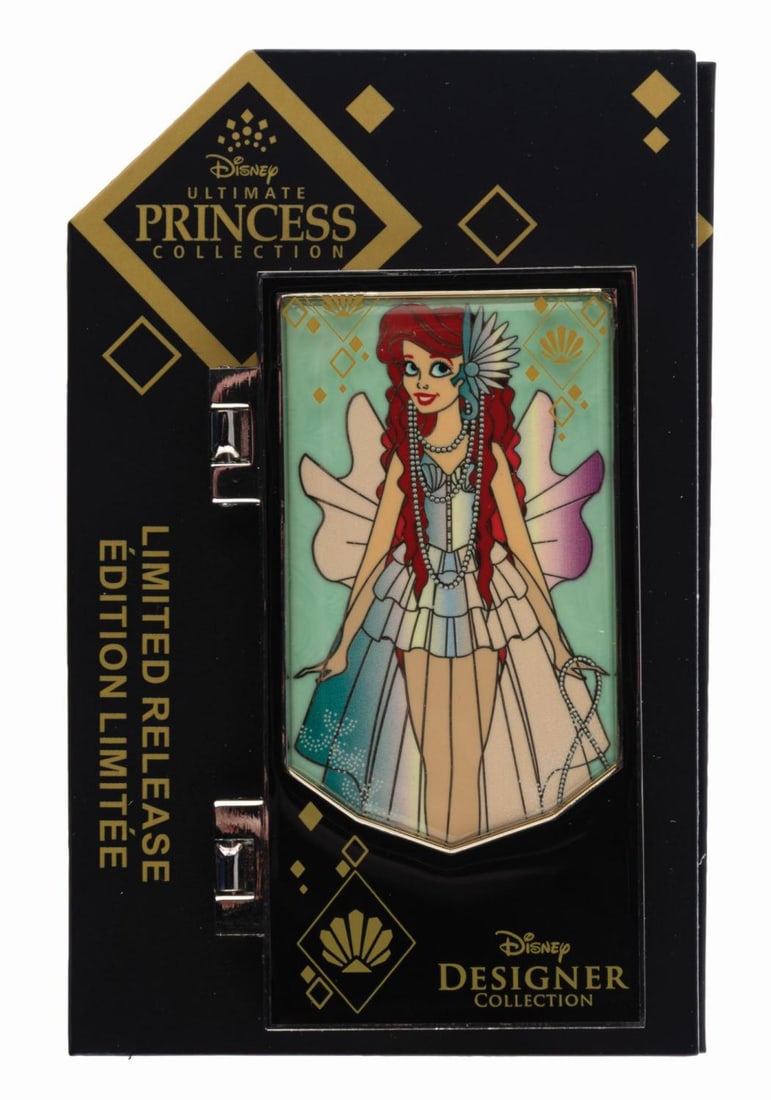 A Disney Designer Ultimate Princess Ariel Pin.: (Disney, 2022) A limited release pin inspired by the Disney Ultimate Princess Ariel doll. The hinged front panel opens to reveal the full Ariel inside, and the card highlights designer Ashley Losada.