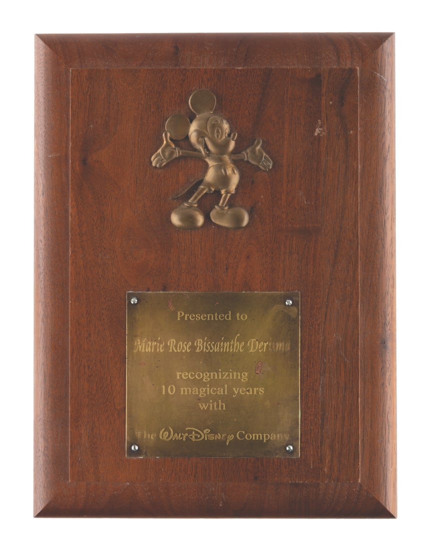 A Walt Disney Company 10 Year Service Award Plaque.: (Disney, 1990s-2000s) A 10-Year Walt Disney Company service award plaque, given to Marie Rose Bissainthe Derisma in recognition of their service to the company. Measuring 9" x 12", the plaque is in
