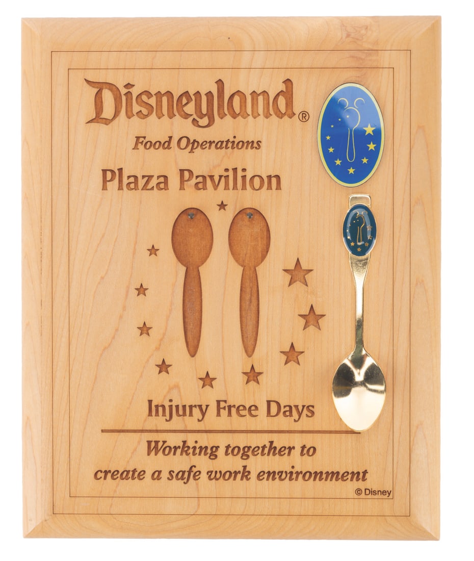 A Plaza Pavilion Cast Member "Injury Free Days" Plaque & Spoon.: (Disneyland, 2000s) A Food Operations plaque and spoon from Disneyland’s “Injury Free Days” for Plaza Pavilion restaurant Cast Members. Included is a Disneyland Food Operations gold colored 