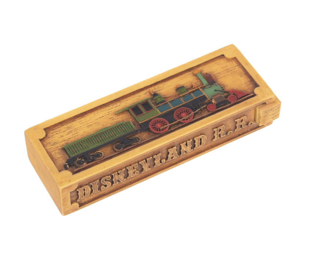 A Disneyland Railroad Olszewski PokitPal.: (Olszewski, 2008) A Disneyland Railroad attraction PokitPal trinket box designed by renowned miniaturist Robert Olszewski. Measuring 3.25", the PokitPal is in very good condition with light wear.