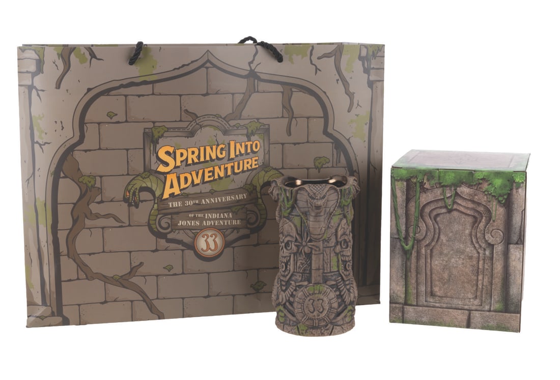 A Club 33 Indiana Jones Adventure 30th Anniversary Tiki Mug and Bag.: (Disneyland, 2025) An Indiana Jones Adventure 30th anniversary tiki mug, sold exclusively at Club 33. The mug features snakes and skeleton warriors from the classic Adventureland attraction, and inclu