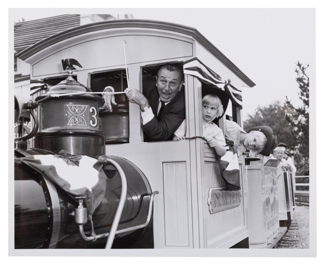 A Walt Disney Nature's Wonderland Publicity Photo.: (Disneyland, 1960) A publicity photo of Walt Disney aboard the inaugural ride of Disneyland’s Mine Train Through Nature’s Wonderland with his grandchildren, Joanna and Tammy Miller. Measuring 8&rd