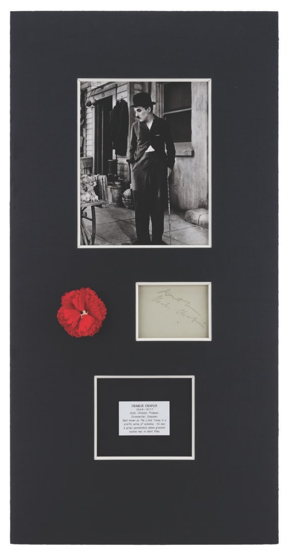 A Charlie Chaplin Matted Signature and Photo.: (Chaplin, 1950s-70s) A photo of Charlie Chaplin and a card signed by "The Tramp" himself, housed in a custom matte with a plaque and faux flower. Measuring 16" x 31.5", the piece is in very good condi
