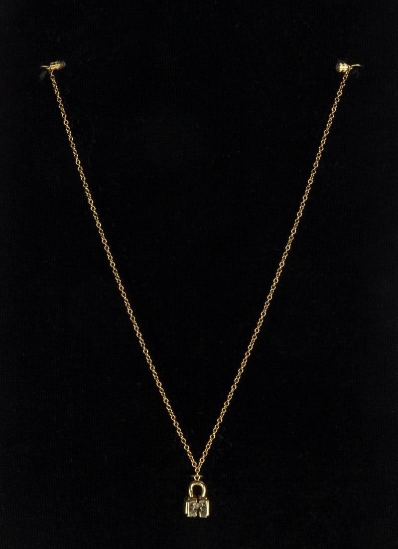 A "One Flew Over the Cuckoo's Nest" Prototype Necklace and Artwork.: (United Artists, 1975) A prototype necklace based on the broken lock seen in the "One Flew Over the Cuckoo's Nest" film logo. Included is a laminated presentation board featuring art for a brochure,