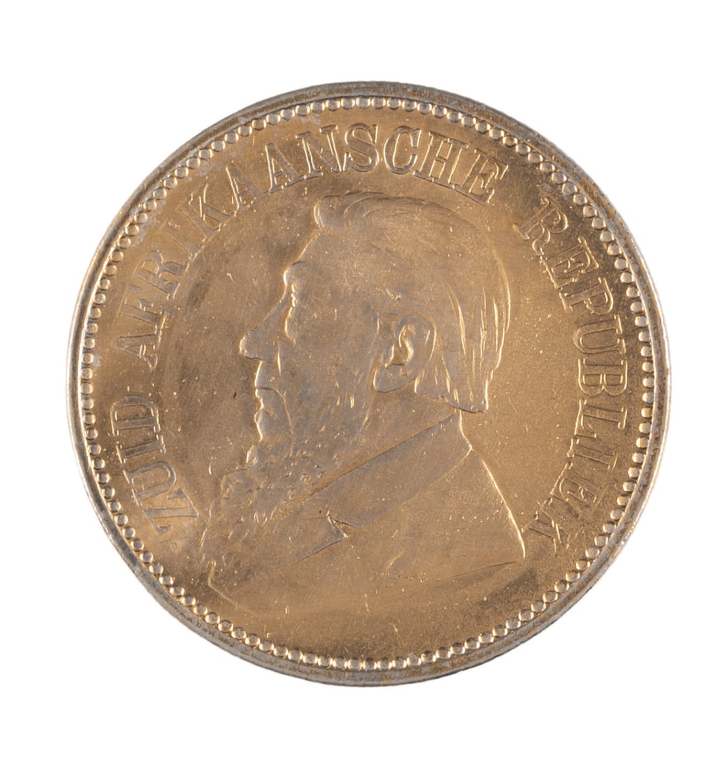 A "Jumanji" Prop Coin.: (Sony, 1995) A prop gold coin from production of the Robin Williams adventure film "Jumanji," styled after actual 1800s South African currency. These coins are used in the movie by the hunter Van