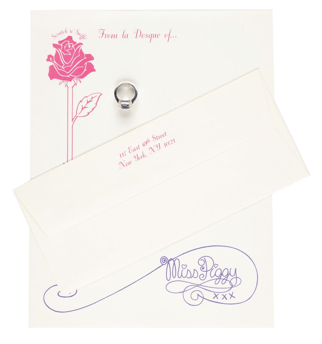 A Miss Piggy Prop Ring and Themed Studio Stationery.: (Henson, 1980s) A prop ring worn by Miss Piggy in one of her many photoshoots and a page of her personal scratch-n-sniff stationery. Included is a matching envelope with the address of Henson