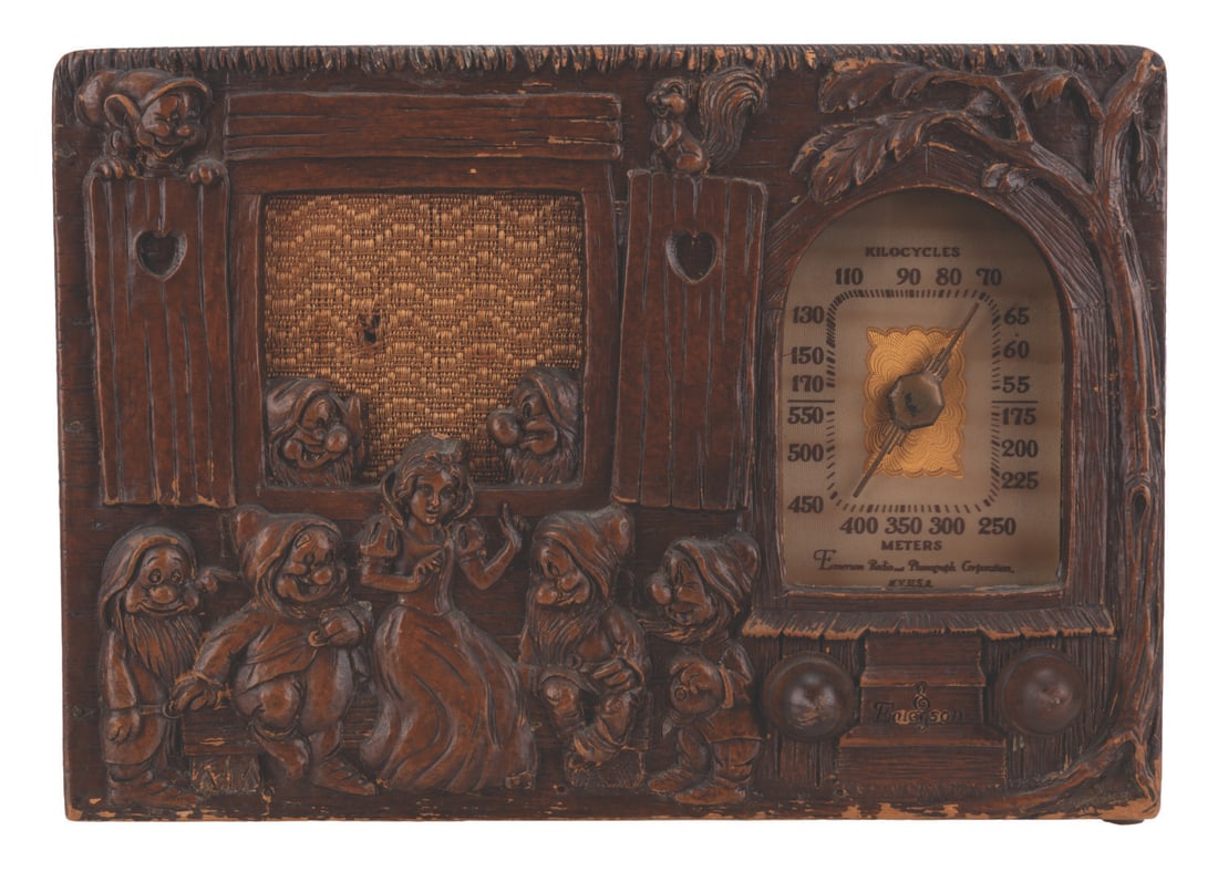 A "Snow White and the Seven Dwarfs" Emerson Radio.: (Emerson Radio & Phono Corp, 1939) An Emerson Model BM247 "Snow White and the Seven Dwarfs" radio. The radio features a figural front panel of Snow White and the Dwarf's cottage, cast in "Repwood," a