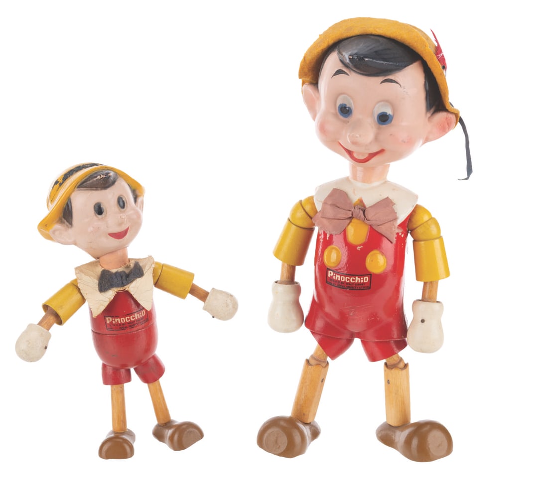 A Pair of Wooden "Pinocchio" Dolls.: (Ideal, 1940s) A pair of wooden jointed dolls with composition heads of Walt Disney's Pinocchio, manufactured by the Ideal Novelty and Toy Company. The hand-painted dolls feature elastic bands and