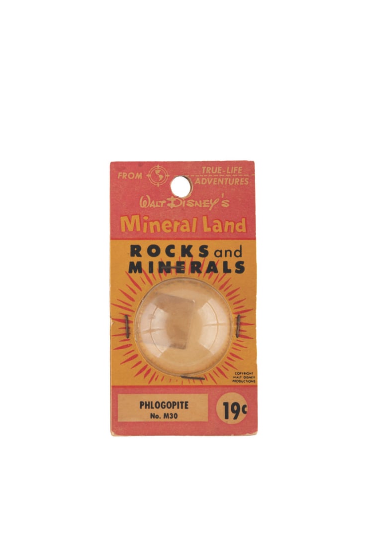 "Mineral Land Rocks and Minerals" Phlogopite.: (Disneyland, 1956) An original "Mineral Land - Rocks and Minerals" capsule from the Mineral Hall, run by Ultra-Violet Products in Frontierland. This 19-cent "Phlogopite" comes in its original