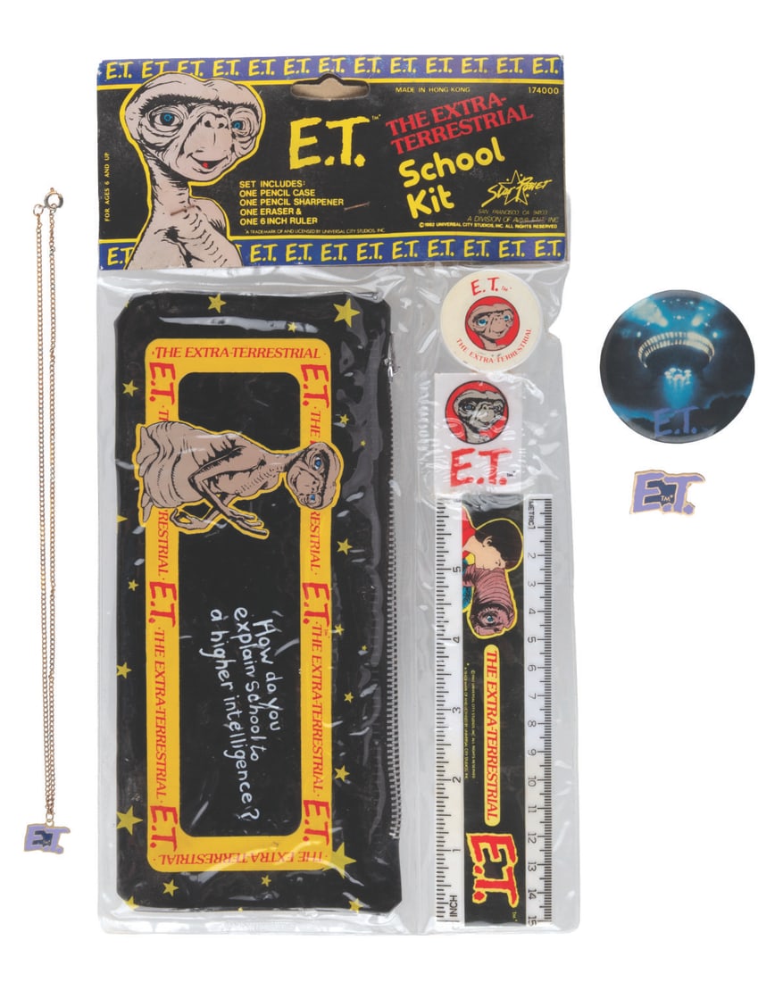 An "E.T. the Extra-Terrestrial" Collection.: (Universal, 1982) An “E.T. the Extra-Terrestrial” collection including a pinback button, a pin, a necklace, and a school supply kit. Included in the kit are a ruler, a pencil case, a pencil