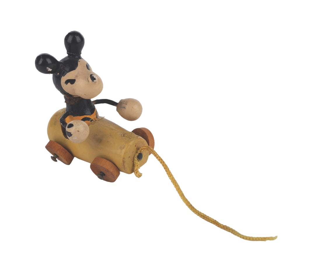 A Miniature Mickey Mouse in Car Pull-Toy.: (Disney, 1930s) A miniature wooden pull-toy of Mickey Mouse riding in a car. Measuring 1.5" x 1.5", the toy is in good condition with paint wear consistent with age, and bending to the wheel pins so