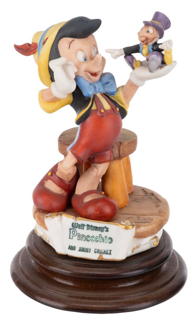 A Pinocchio & Jiminy Capodimonte Porcelain Figure.: (Disney, 1985) A Capodimonte porcelain Pinocchio and Jiminy Cricket figure sculpted by Enzo Arzenton for the Laurenz Disney Character Collection. Released in an edition of 5000, the porcelain figure