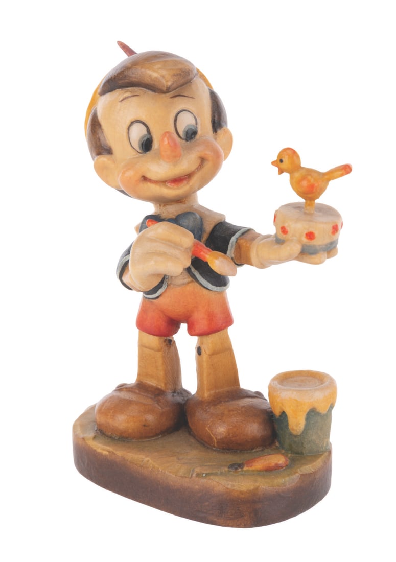 A Wood-Carved Pinocchio Figure by Anri.: (ANRI, 1995) A wood-carved figure of Pinocchio crafted by renowned Italian woodcarving company ANRI. The figure was released in a limited edition with this piece numbered 646. Measuring 4" tall,