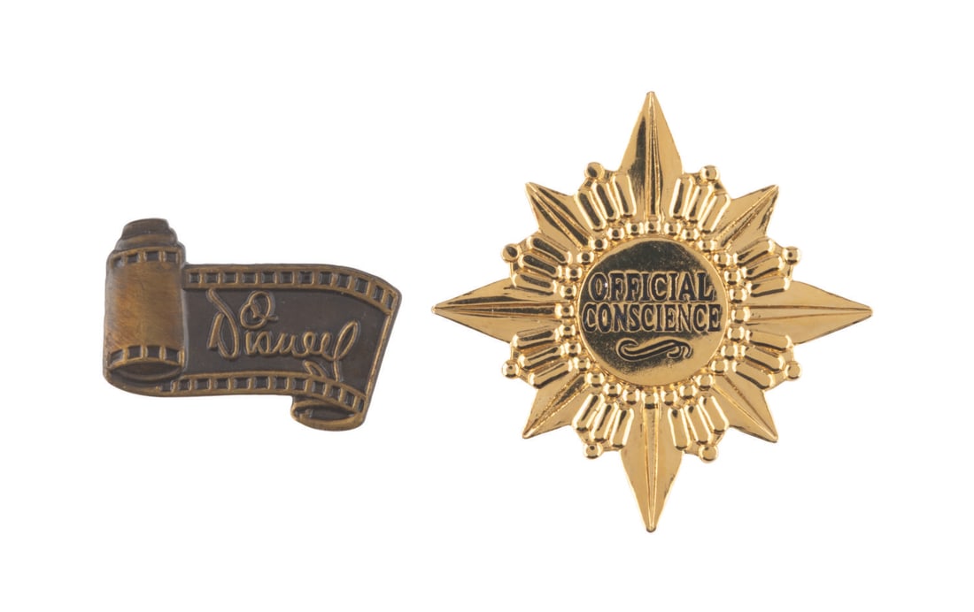 A Pair of WDCC "Official Conscience" & Disney Film Scroll Pins.: (WDCC, 1997) A Walt Disney Classic Collection Jiminy Cricket "Official Conscience" pin given as a gift with purchase during the 1997 Fall Sculpture Event. Also included is a WDCC "Disney" film scroll