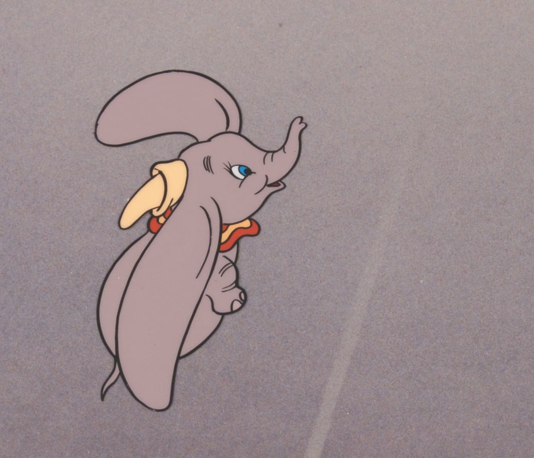 A Production Cel of Dumbo from a Commercial.: (Disney, 1960s-90s) A production cel of Dumbo from an unknown commercial, presented with a color photo background. With a character image size of 2.5" x 1.5" on the 10.5" x 12.5" cel, the piece displa