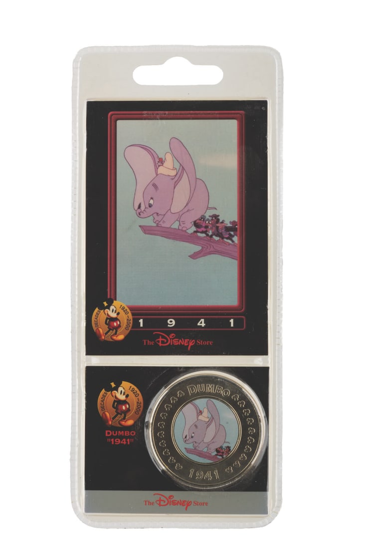A "Dumbo" Disney Decades Coin and Card Set.: (Disney, 2000) A Disney Decades coin and collector card of 1941?s "Dumbo." The set is in fine condition sealed in the original packaging.