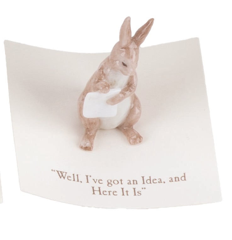 A Mini "Winnie the Pooh" Rabbit Figurine.: (Michel and Co., 1990s) A mini ceramic figurine of Rabbit, inspired by the original illustrations for the Winnie the Pooh books by E. H. Shepard. The figurine is attached to a card with a quote that r