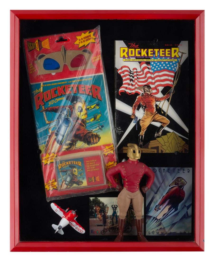 A Framed "The Rocketeer" Collection.: (Disney, 1991) A framed collection of "The Rocketeer" merchandise, including a vinyl model of the Rocketeer, an official movie adaptation comic book, a sealed 3D comic with an audio tape, a die-cast m